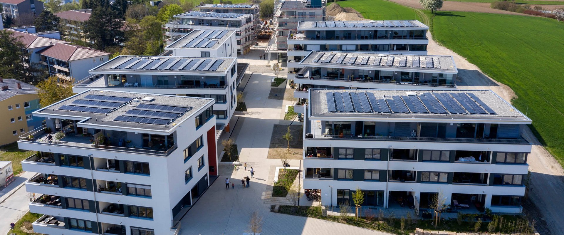 Neubau-Wohnquartier mit Solaranlagen und grünem Panorama.